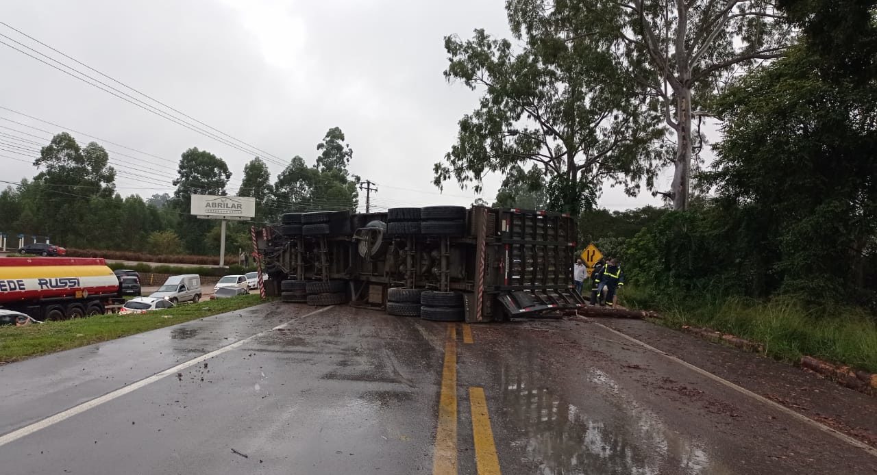 Caminhão carregado toras de madeira tomba e interdita BR 470 no