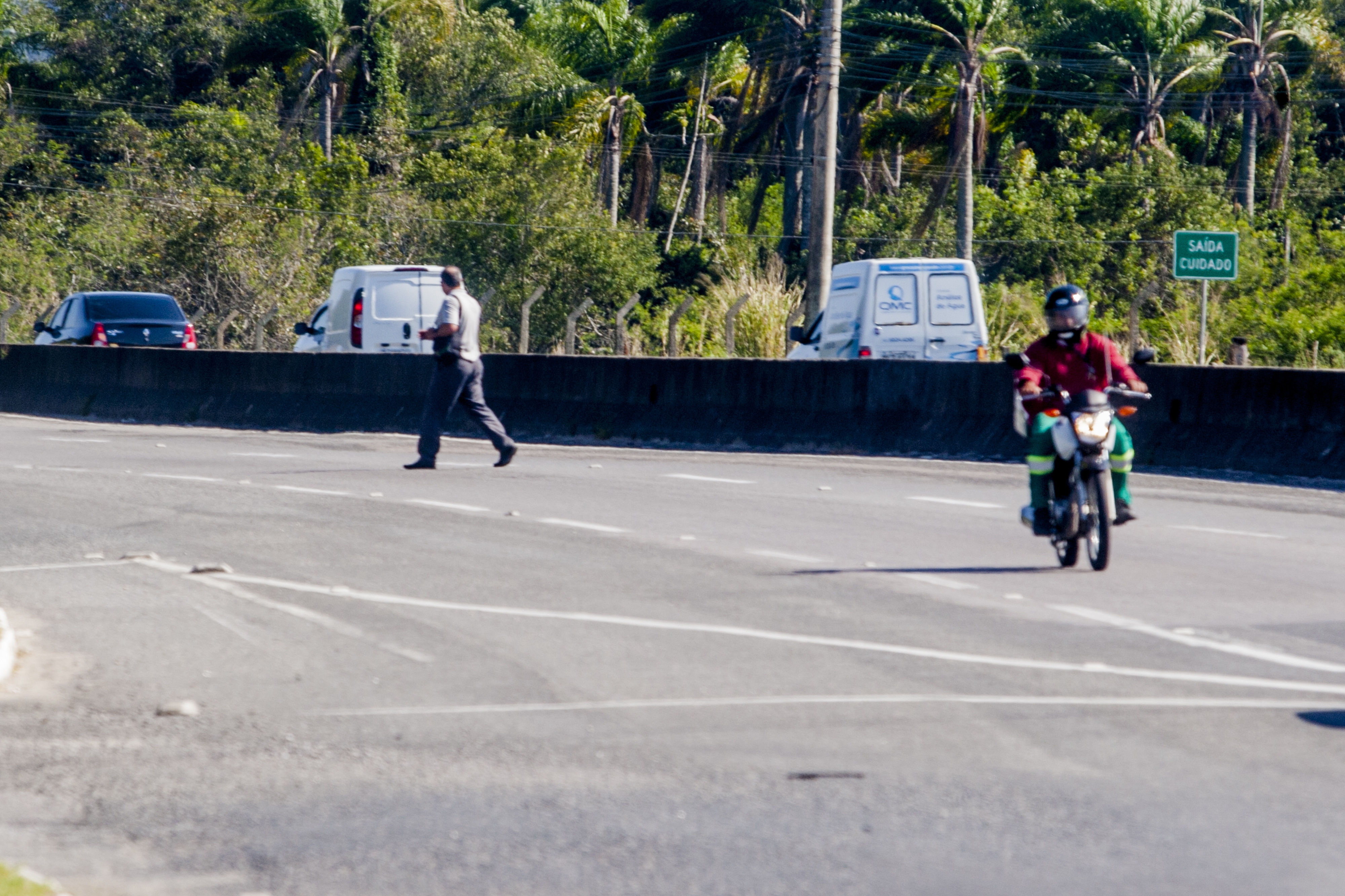 Pedestre pula a mureta que separa as pistas da SC-401 e atravessa a rodovia em meio aos veículos - Flávio Tin/ND