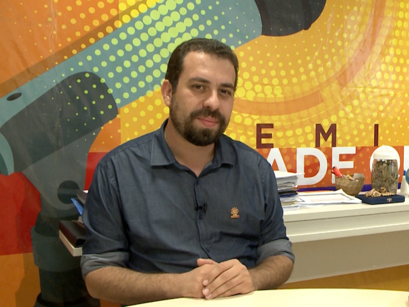 Guilherme Boulos sentado em uma mesa