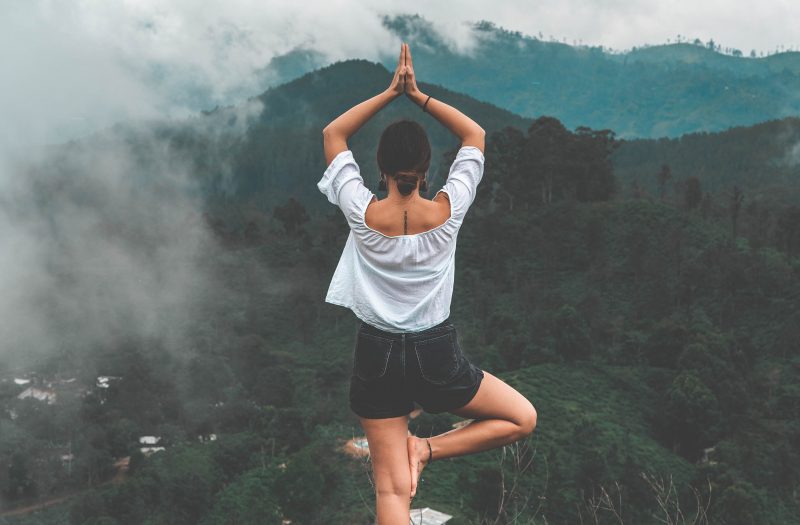 Mulher fazendo yoga em uma montanha