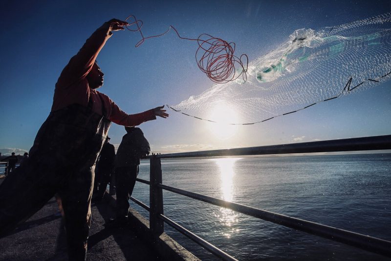 Pescador atirando rede em cidade no litoral de SC