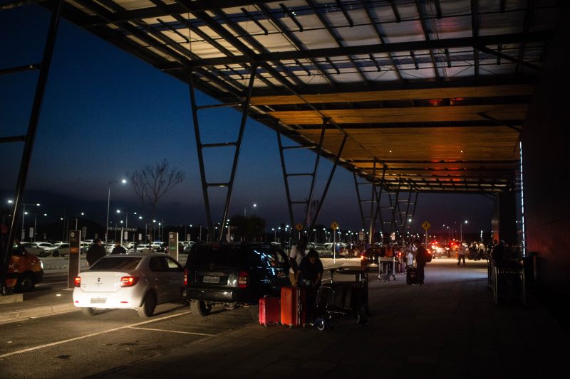 Passageiros aguardam no escuro para deixar o aeroporto, pois a iluminação da entrada do Boulevard não está pronta – Flavio Tin/ND