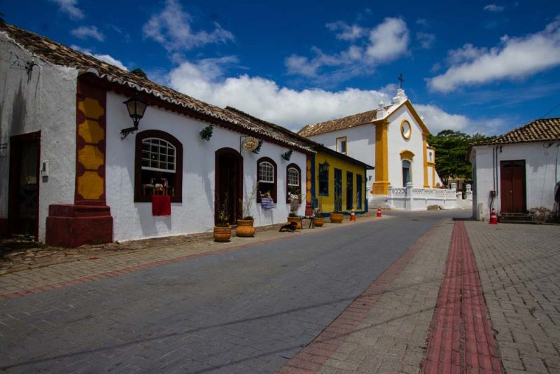 Foto mostra casarões e Igreja em estilo arquitetônico luso-brasileiro em Santo Antônio de Lisboa, em Florianópolis. O bairro fica a sete quilômetros do chalé romântico Casa Ivan. 