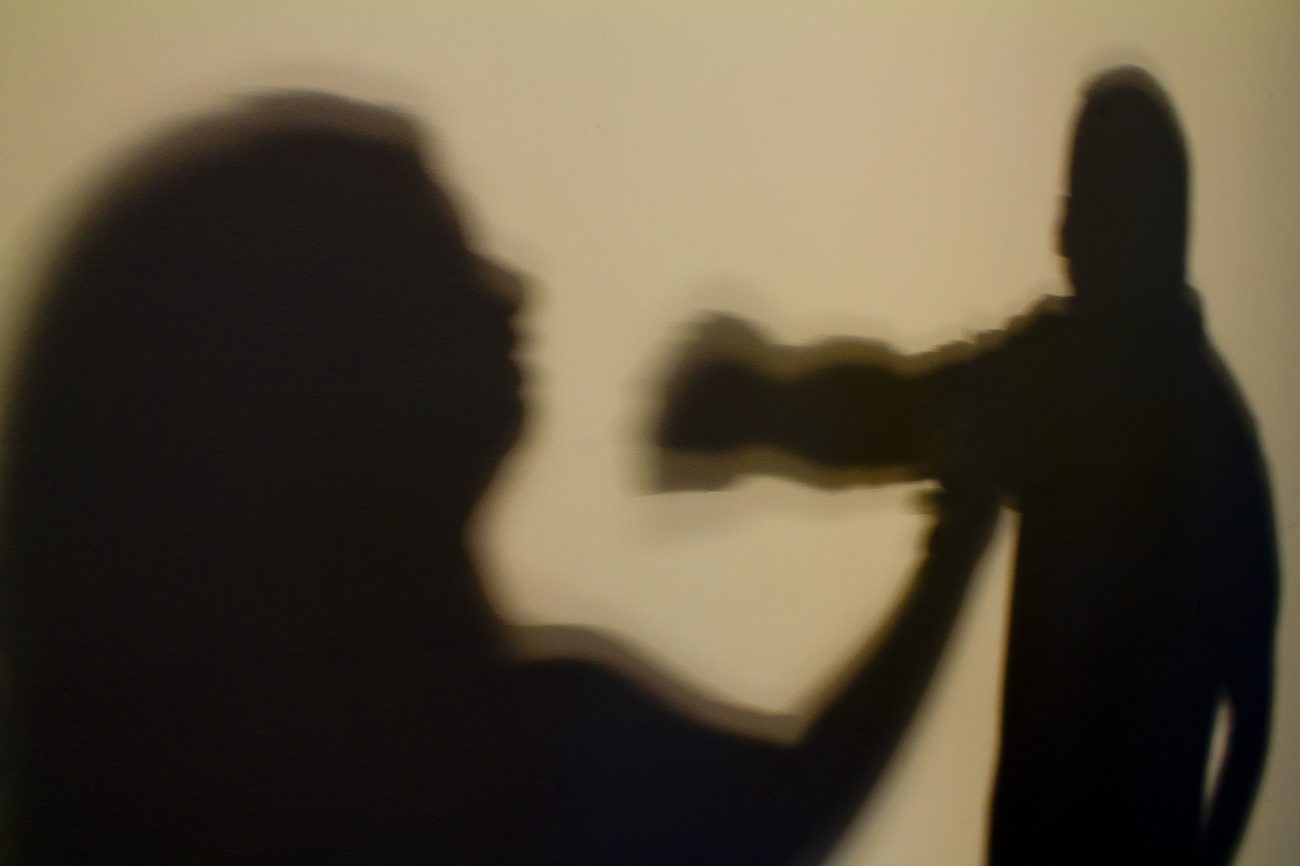sombra de um homem e uma mulher sofrendo agressões com um soco vindo em sua direção sombra de um homem e uma mulher sofrendo agressões com um soco vindo em sua direção