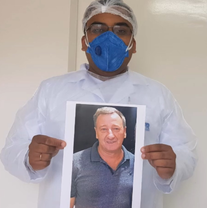 Ivor Demetrio Fossatti, de 56 anos, foi a primeira vítima de Covid-19 no Oeste catarinense. Morador de Tangará, ele foidiagnosticado com coronavírus no dia 1º de abril, após voltar de uma viagem ao litoral catarinense apresentando fortes sintomas da doença. Com o agravamento da infecção, ele foi internado em UTI, mas morreu no dia 18 de abril. Fossatti sofria de problemascardíacos, que o levaram a fazer uma cirurgia no coração. Ele trabalhou por mais de 20 anos como Vigilante Sanitário na prefeitura de Tangará. Após a morte, colegas gravaram um vídeo em homenagem. Na imagem, um colega segura uma foto de Fossatti. Confira a reportagem completa: <a href="https://bit.ly/2yt0KZp">https://bit.ly/2yt0KZp</a> - Reprodução/Facebook