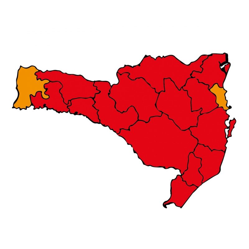 Imagem do mapa de santa catarina dividido por regiões de saúde. O mapa está em vermelho, exceto duas áreas.