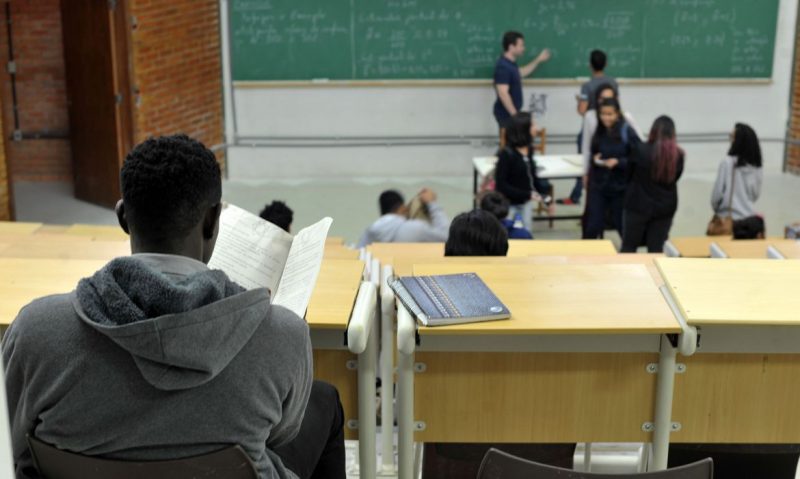 Homem negro estudando em bancada de universidade 