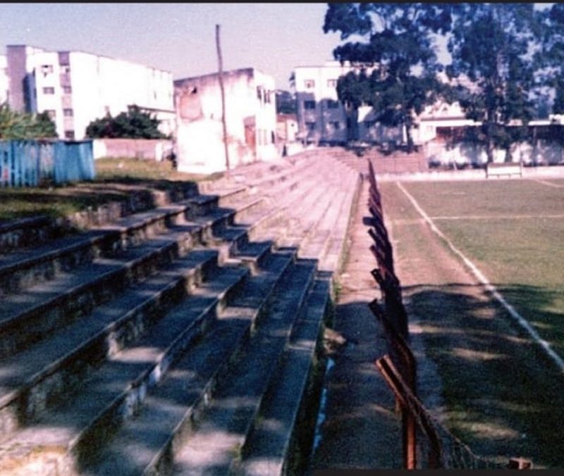 A nova geração de torcedores de Avaí e Figueirense não consegue imaginar a estrutura – ou a falta dessa estrutura – no antigo e saudoso estádio Adolfo Konder, que ficava localizado onde hoje funciona o Beira Mar Shopping, no centro de Florianópolis. Na foto, a arquibancada e ao fundo, as árvores que ficavam pelo lado da rua Altamiro Guimarães. Aqui nesse “Maracanã” grandes esquipas extintas da capital desfilaram seus bons jogos de futebol. – Foto: Adalberto Klüser/ND