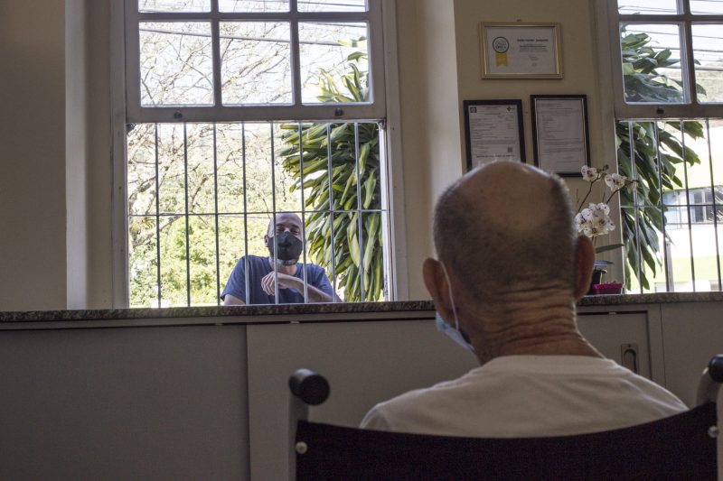 Sandro Machado, assim como o irmão, faz questão de manter os encontros pela janela para ativar a memória do pai que vive no lar desde 2012 e que teve as visitas presenciais suspensas desde março – Foto: Anderson Coelho/ND