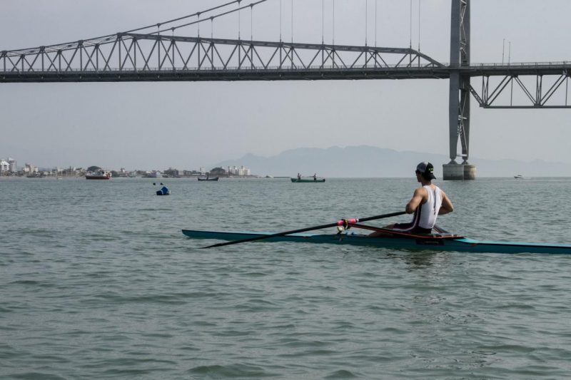 Augusto Knoll durante o treino, remando próximo a ponte Hercílio Luz