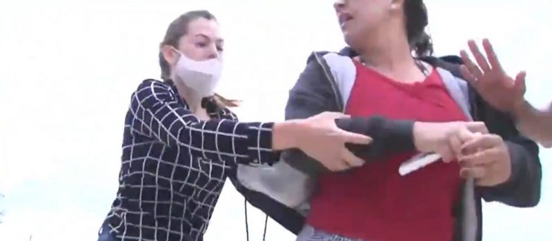 Momento em que a rep&oacute;rter (&agrave; esq.) tenta recuperar o aparelho tomado por uma mulher – Foto: NSCTV/Reprodu&ccedil;&atilde;o/ND