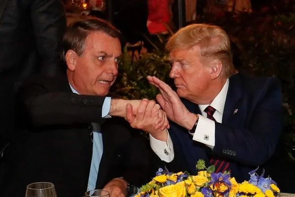 Fotografia de Bolsonaro e Trump juntos em uma mesa