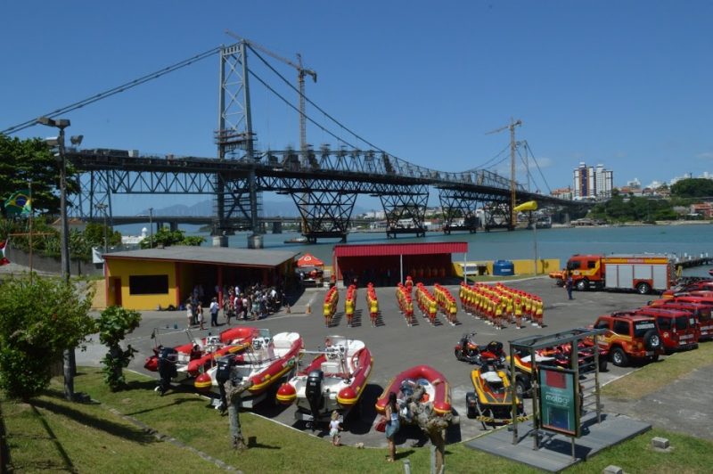 Solenidade de formatura do Corpo de Bombeiros. Ao fundo a ponte Hercílio Luz.
