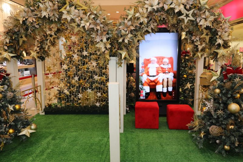 Totem virtual com Papai Noel e Mamãe Noel. Há decoração de natal