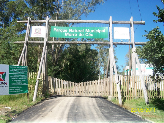 Entrada do Parque Municipal Morro do Céu, aparecem vegetação e uma cerca 