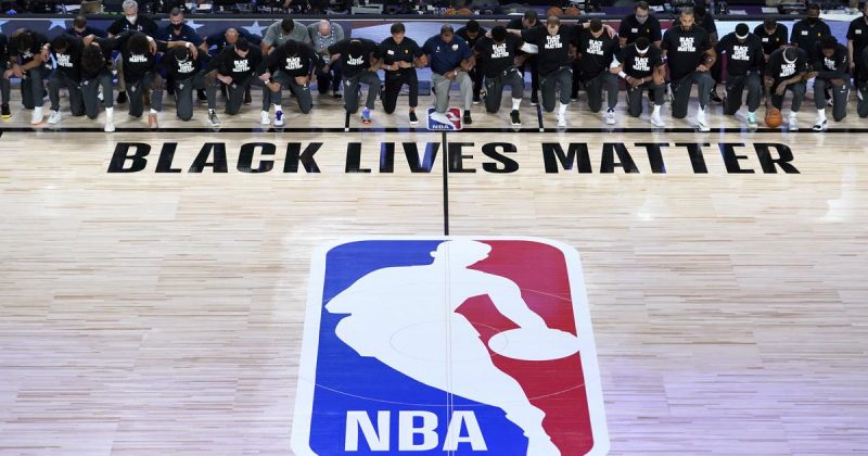 A NBA foi retomada em meio à efervescência de manifestações nos Estados Unidos motivadas pelo assassinato de George Floyd, morto brutalmente por policiais. Diversos jogadores foram às ruas e participaram das manifestações enquanto a NBA estava paralisada. Já na bolha, o assassinato de Jacob Blake, baleado nas costas por policiais brancos em Wisconsin, motivou ainda mais manifestações. Times inteiros se recusaram a entrar em quadra e uma rodada inteiro precisou ser cancelada. Atletas, equipes chamaram a atenção para o racismo institucional e policial na América do Norte. Na quadra “Black Lives Matter”, nas camisas, mensagens como “Say her name” e o próprio “Black Lives Matter” – Foto: NBA/Divulgação