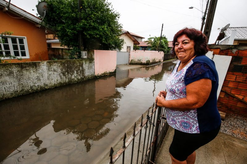 Moradora olha para rua alagada 