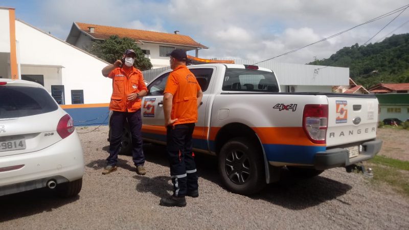 Foto de viatura e profissionais da defesa civil do estado conversando.