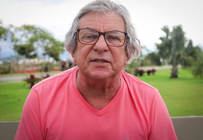 Sadi Peixoto, ex-prefeito de Biguaçu, vestido com uma camisa rosa, em uma praça