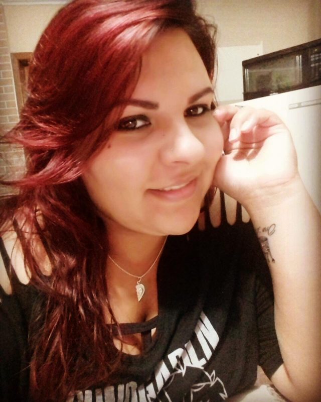 Larissa Muller, mulher com cabelos coloridos, camisa preta, sorrindo