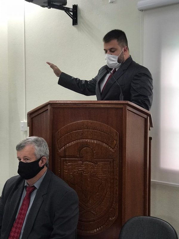 Tiago Dalsasso fazendo seu juramento; abaixo, seu vice, Moacir Dalla Brida