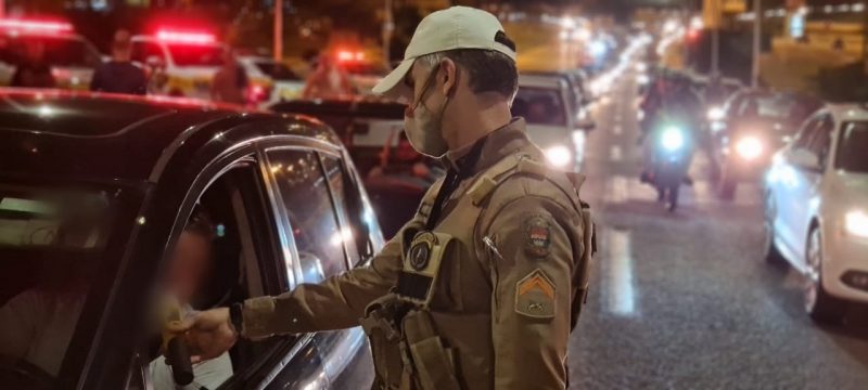 Policial faz teste de bafômetro em motorista à noite