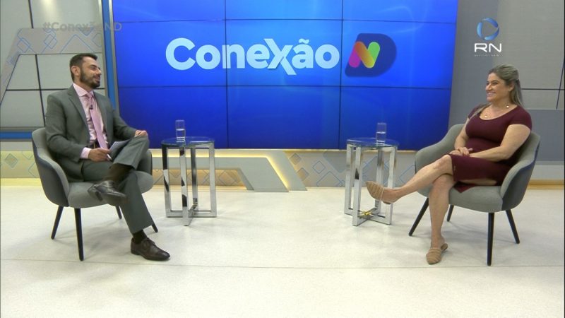 Alexandre Mendonça e Carolina Buendgens no estúdio com a marca do Conexão ND ao fundo