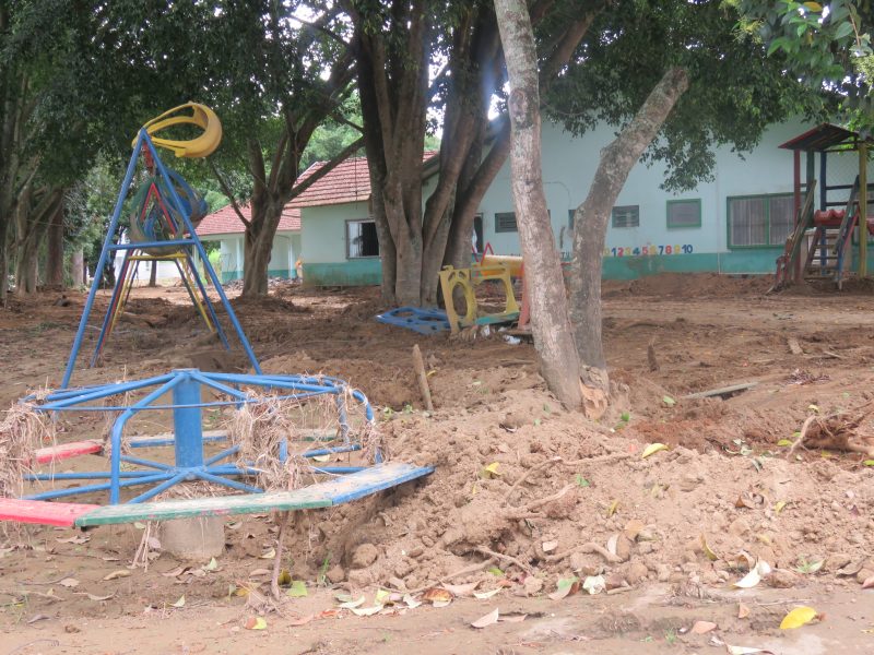 Foto de um parquinho infantil onde há bastante barro ao redor.