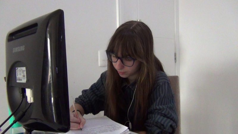 Aluna estudando diante de uma tela de computador