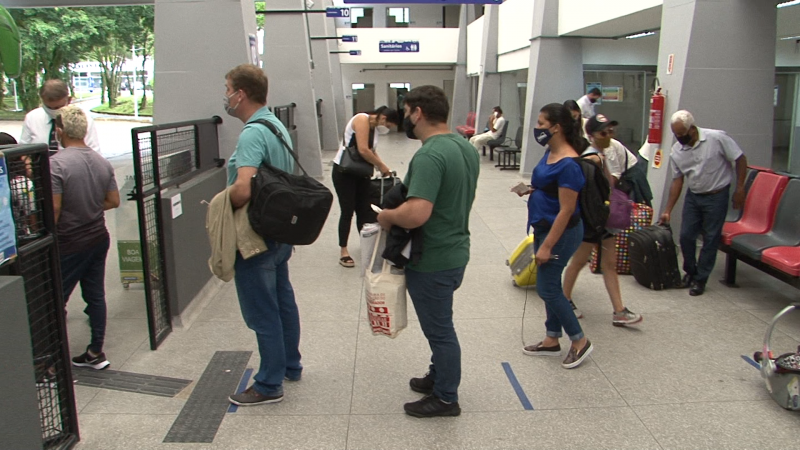pessoas em fila usando máscara