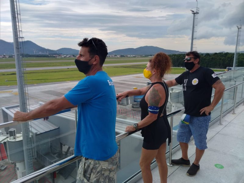 Três pessoas no terraço panorâmico do aeroporto de Florianópolis