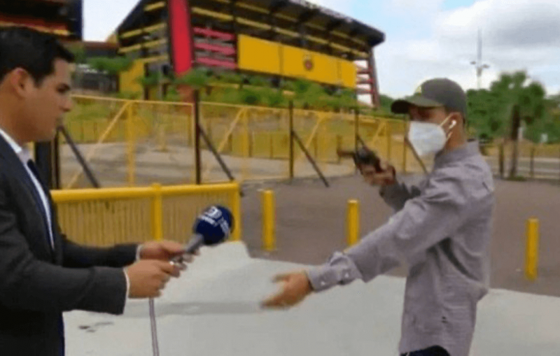 Assaltante aponta arma para o rep&oacute;rter, surpreendido ao vivo – Foto: Reprodu&ccedil;&atilde;o