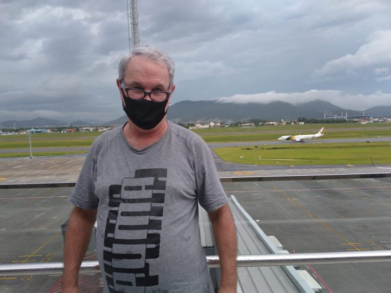 Edilson Carneiro, com o avião presidencial ao fundo, no aeroporto de Florianópolis