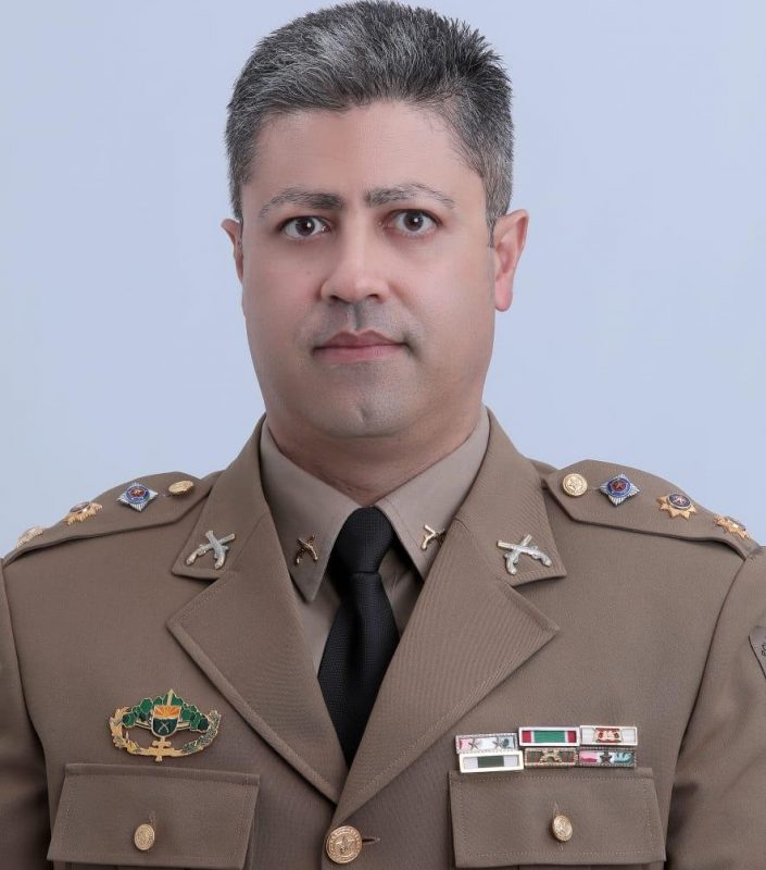 tenete-coronel Pimentel com a farda da Polícia Militar de Santa Catarina. A roupa é marrom claro e ele está com uma gravata preta. Ele está sério na foto e seu cabelo é grisalho. Seus olhos são castanho escuro.