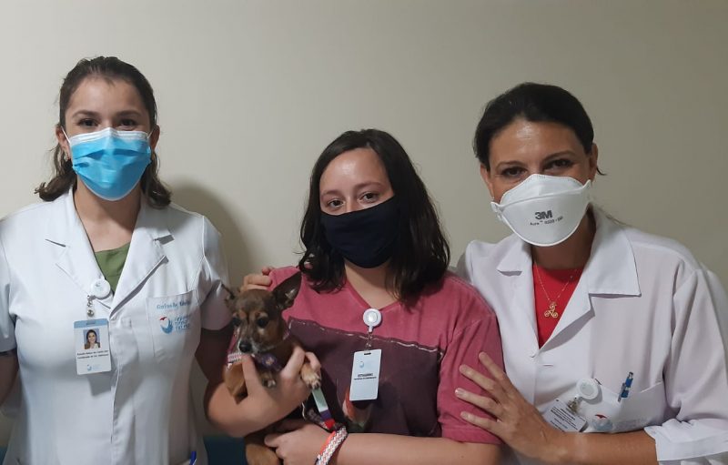 Lilica foi visitar o seu tutor acompanhada de uma familiar e foi recepcionada pela enfermeira Rafaella (esquerda) e a psic&oacute;loga Maria Jos&eacute; (direita) – Foto: Hospital Dona Helena/Divulga&ccedil;&atilde;o