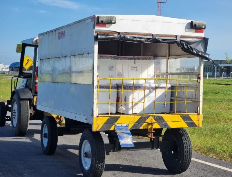 Vacinas sendo levadas pelo trator no Aeroporto de Florianópolis