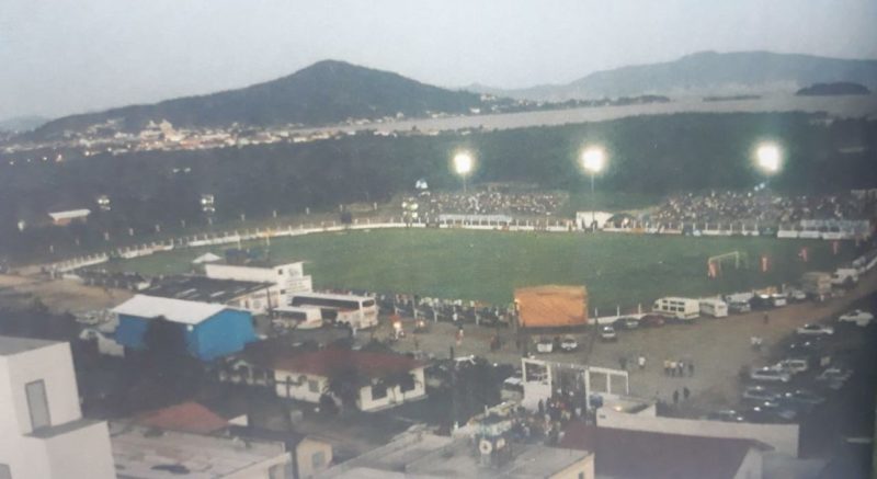 Em 2004, o est&aacute;dio Renato Silveira, no centro de Palho&ccedil;a, viveu uma noite de gala, inesquec&iacute;vel. A torcida invadiu as arquibancadas para assistir a vit&oacute;ria do Guarani sobre o Figueirense por 1 x 0, gol de Ramon. – Foto: Guarani de Palho&ccedil;a, 90 anos/reprodu&ccedil;&atilde;o/ND