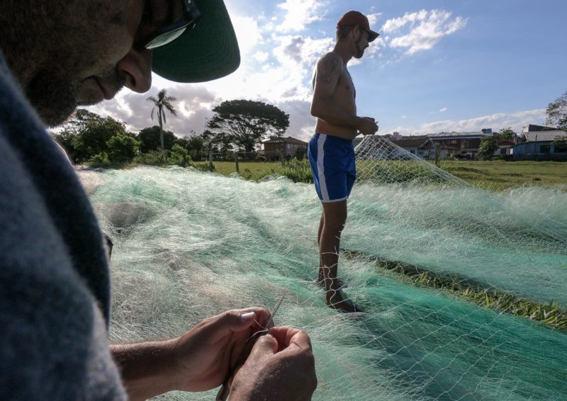 Pescadores da Ilha ajustando rede anilhada para pesca da tainha