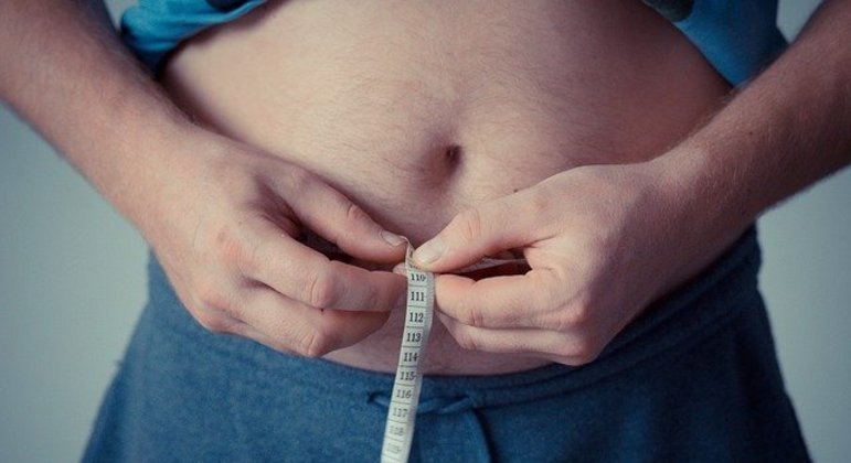 homem mede o quanto você deve pesar na barriga e vê que está acima do peso