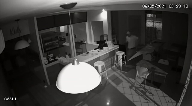 Imagens mostram que assaltante chegou sozinho, arrombou porta de vidro e roubou celular de tr&aacute;s do balc&atilde;o – Foto: Reprodu&ccedil;&atilde;o/ND