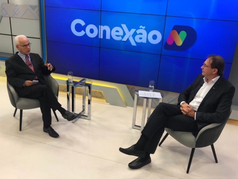 Moacir Pereira aparece conversando com presidente da Fiesc e telão na parte central escrito Conexão ND com o fundo azul