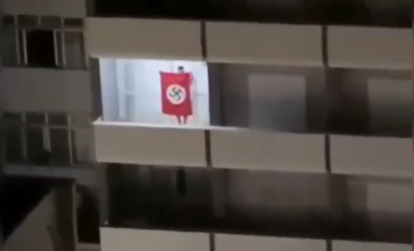 Homem é visto em janela com bandeira nazista – Foto: Divulgação/ND