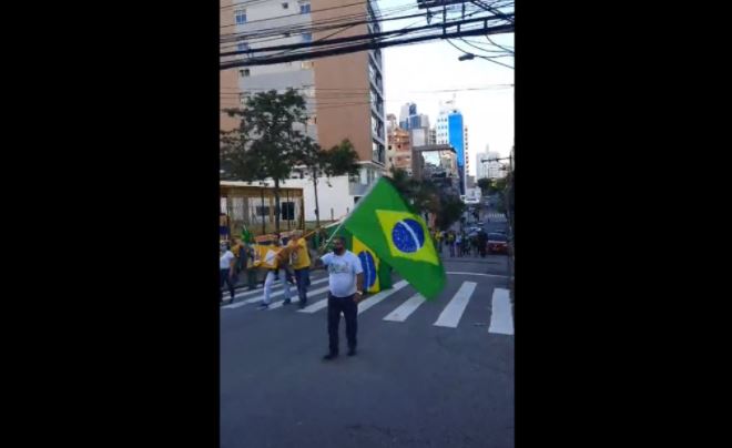 Imagem mostra homem segurando bandeira do Brasil
