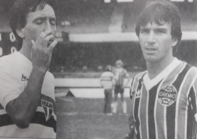 Numa partida entre S&atilde;o Paulo e Gr&ecirc;mio no in&iacute;cio dos anos 1980, o encontro entre dois irm&atilde;os catarinenses que fizeram sucesso no cen&aacute;rio do futebol nacional. Pelo tricolor paulista, o volante Almir Gil. Pelo Gr&ecirc;mio, o meia-atacante Tonho. Nessa fam&iacute;lia de craques, despontou outro grande jogador, o tamb&eacute;m meia S&eacute;rgio Gil, que do Figueirense foi brilhar no Corinthians, mas que nos deixou precocemente v&iacute;tima de uma acidente de carro em 1989. – Foto: Hist&oacute;ria do F. CatarinC. Machado/reprodu&ccedil;&atilde;osar