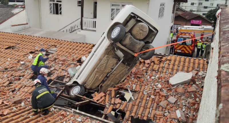 Carro capota e cai em cima de telhado em Blumenau – Foto: St&ecirc;v&atilde;o Limana/NDTV