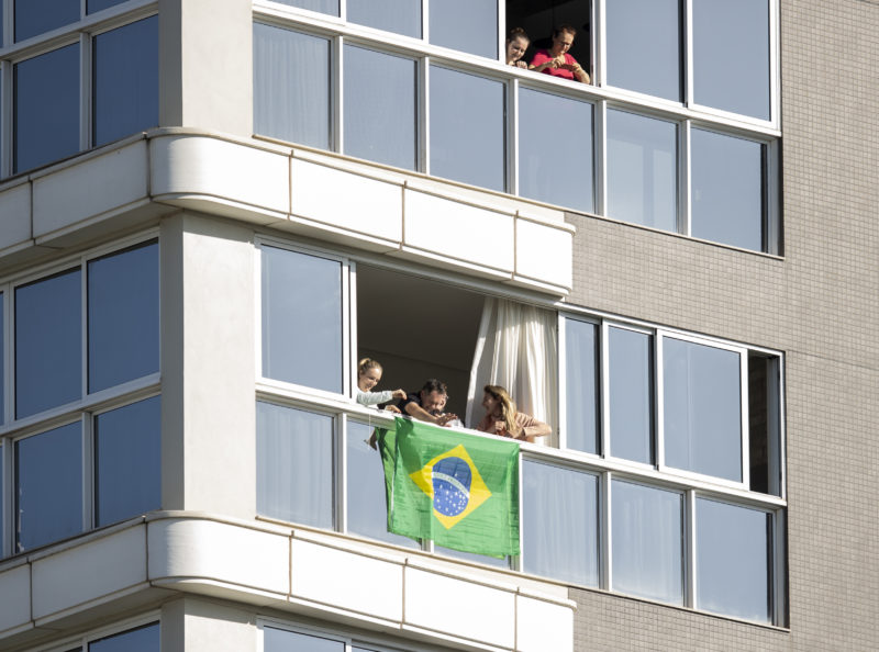 Apoiadores de Bolsonaro acompanhavam a visita do presidente pela sacada de um prédio de Chapecó. – Foto: Liamara Polli/Especial ND