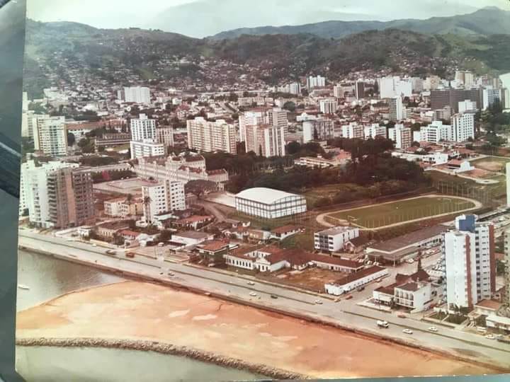 Na década de 1980, o aterro invadia a região da Beira Mar para a ampliação das pistas da avenida. Mas o destaque desta foto aérea fica para o campo de futebol do Colégio Catarinense, local onde surgiu o futebol amador e depois profissional do da capital. Aqui foram disputados os primeiros campeonatos estaduais da história. – Foto: Casa da Memória/ND