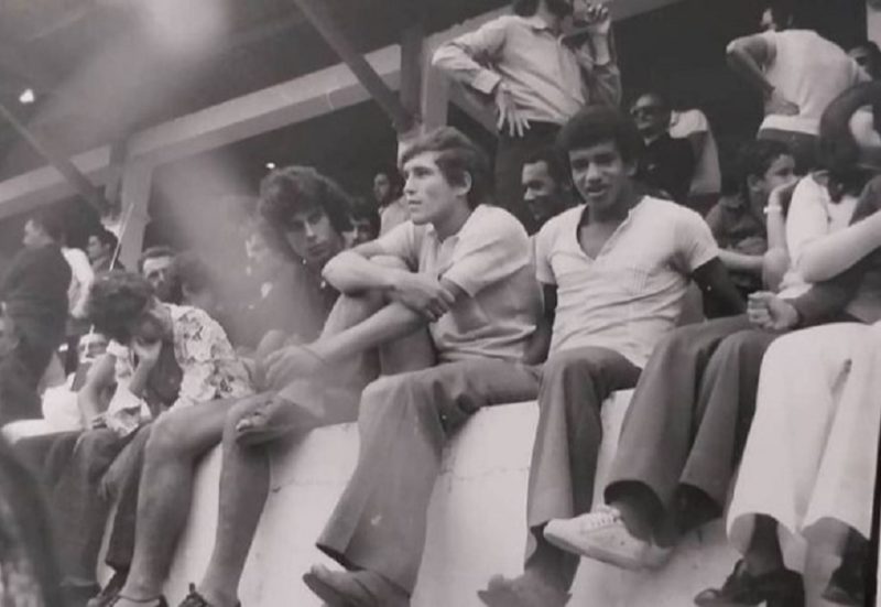 Na foto do início da década de 1970, o atacante Tião Marino aparece sentado entre os meias Caco e Luiz Everton (camisa escura) em um momento de pura descontração nas arquibancadas entre os torcedores, aqui na capital. Esse trio deu muitas alegrias para os torcedores do Figueirense. Luiz Everton e Caco, depois mais tarde, vestiram a camisa do Avaí. – Foto: Tião Marino/Jorge Custódio/mídia social/ND