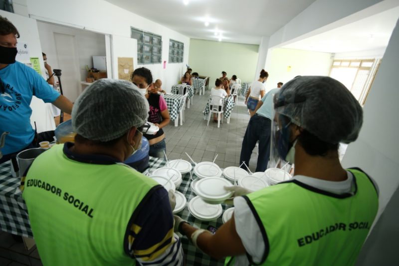 Trabalhadores atuando em distribuição de alimentos na Passarela da Cidadania