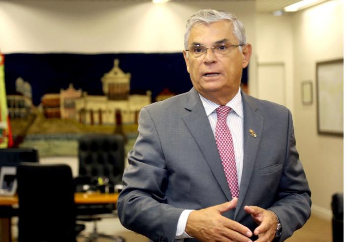 Eduardo Pinho Moreira de terno cinza e gravata vermelha